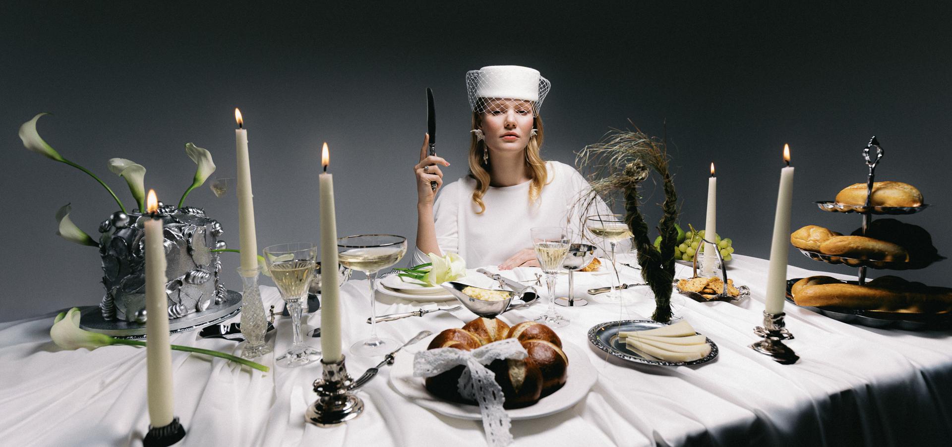 Nevesta so závojom a perlovými náušnicami stojí tvárou pri ženíchovi, obaja sú zachytení v jemnom romantickom momente v exteriéri.