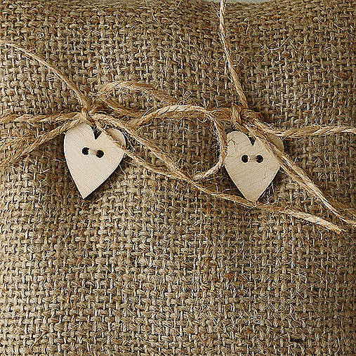 Svadobný vankúšik z juty s drevenými srdiečkami.