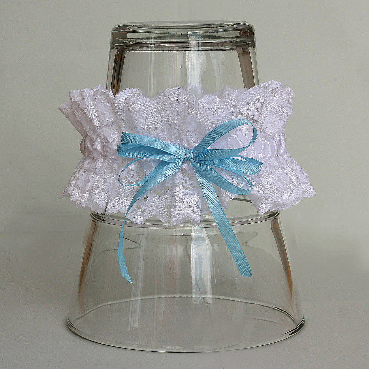 Biely čipkovaný podväzok s modrou mašličkou