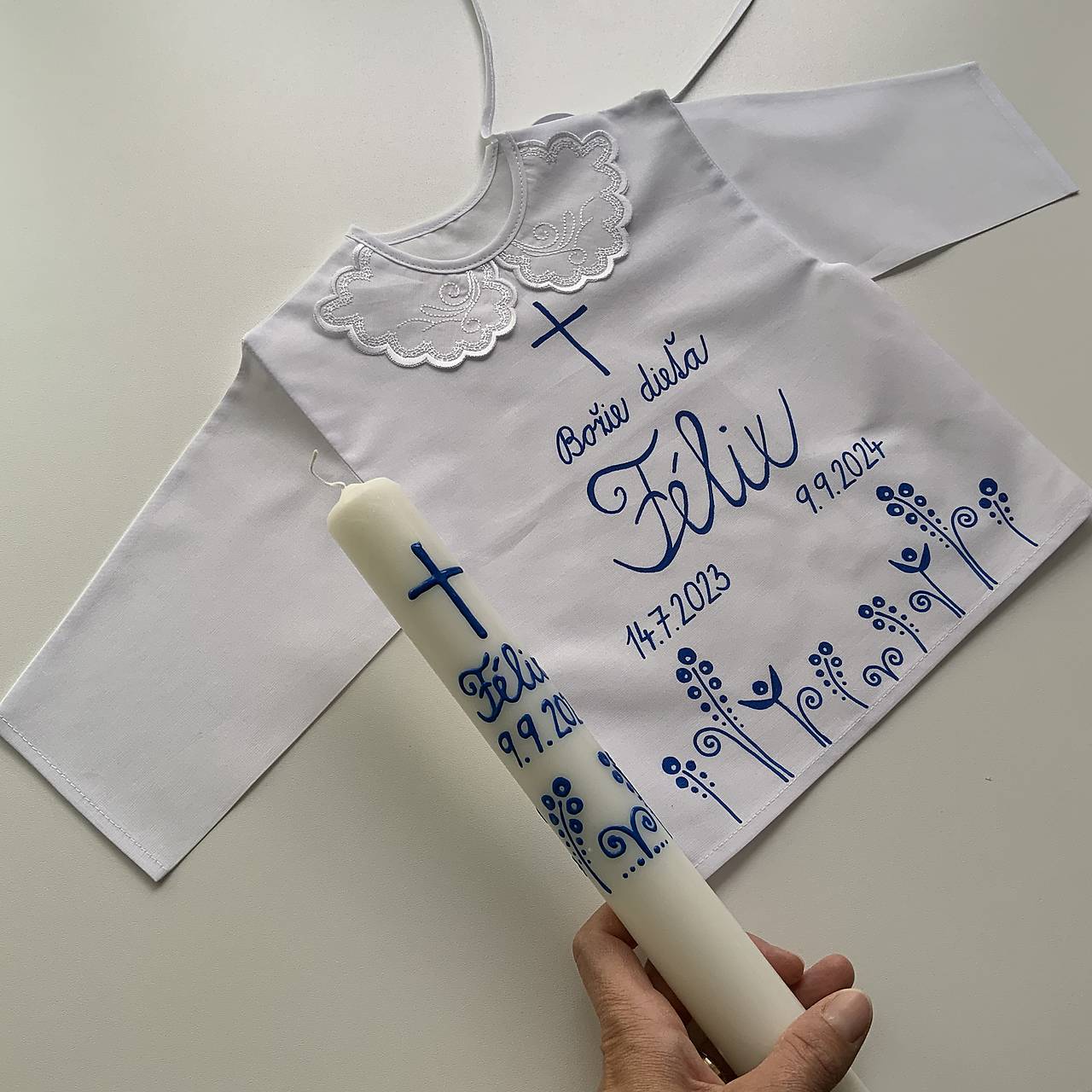 Krstná košieľka a svieca na krst ručne maľovaná ľudovoladená  (s krížom v hornej časti a s kvetmi v modrom)