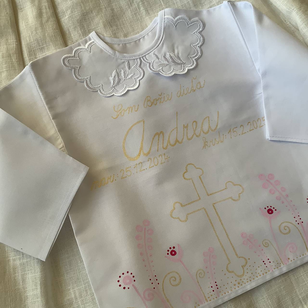 Krstná košieľka ručne maľovaná  s krížom a ľudovoladeným rastlinkami v ružovo - zlatej farbe 