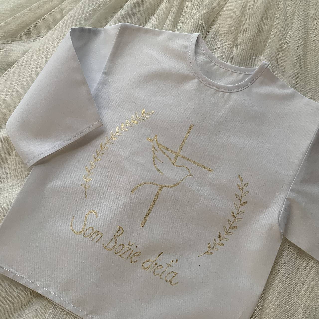Krstná ručne maľovaná košieľka s holubicou a krížom a jemnými vetvičkami v zlatej farbe 