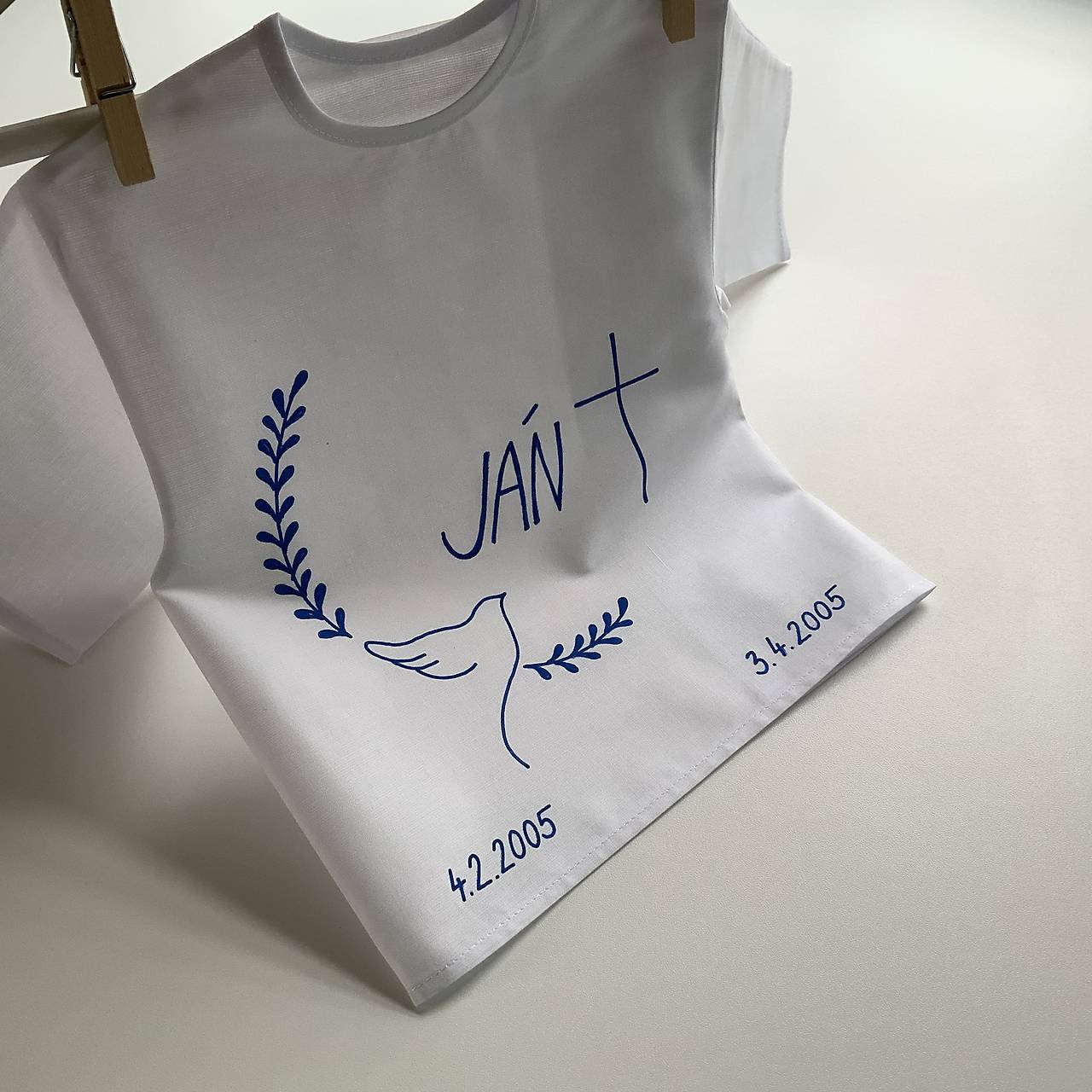 Krstná košieľka ručne maľovaná s holubicou, menom a ratolesťami v modrom
