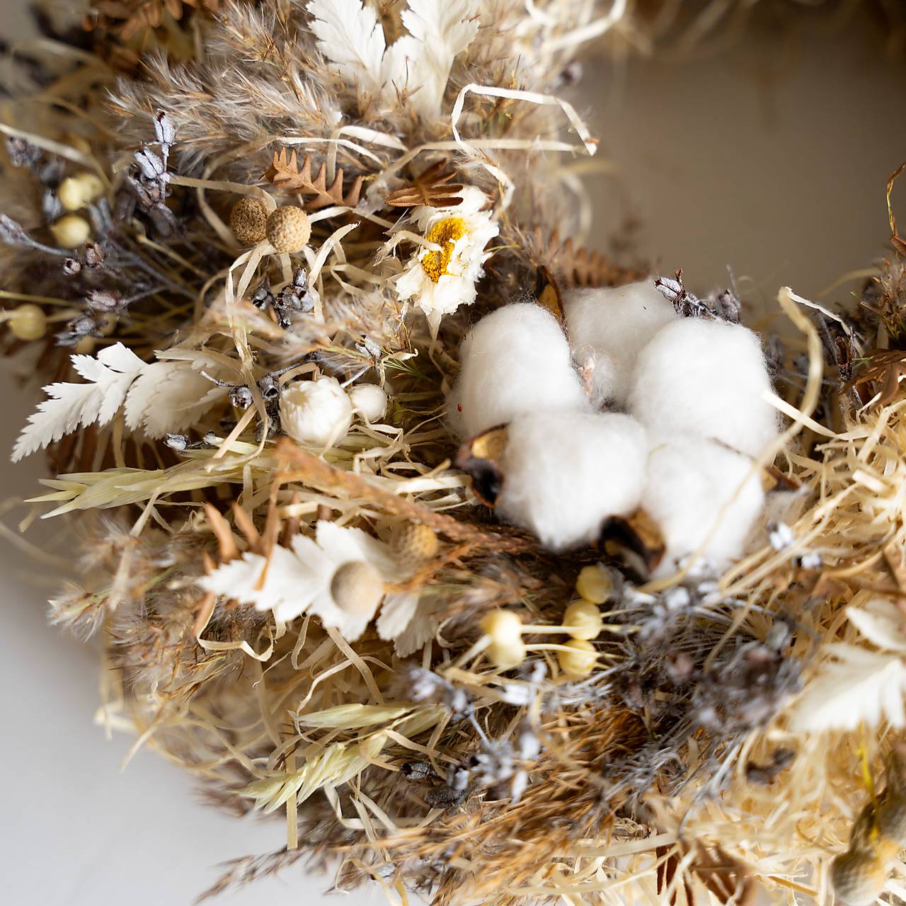 Veniec zo sušených tráv a bielych kvetov slamienok.