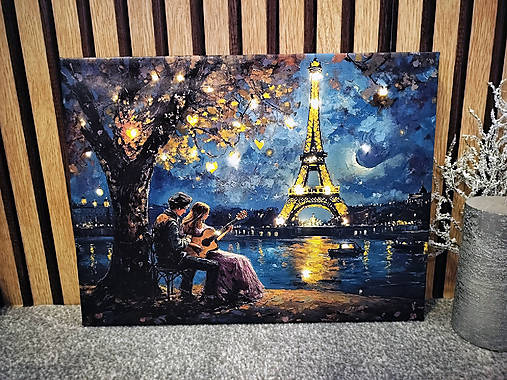 Svietiaci obraz pár s gitarou pod Eiffelovou vežou