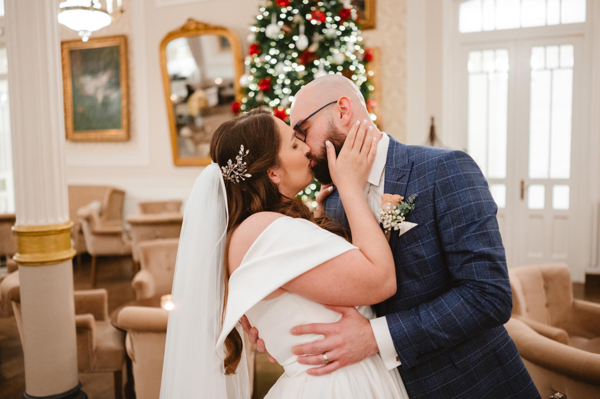 nevesta s dlhým závojom a ženich v modrom obleku, hotel lomnica, bozkávajú sa