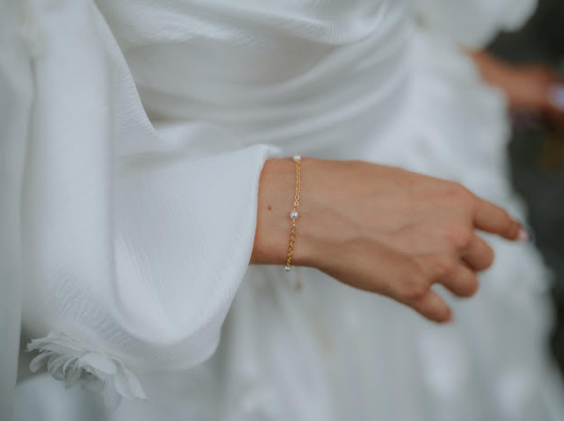 detail na ruku nevesty s jemným náramkom s perlami