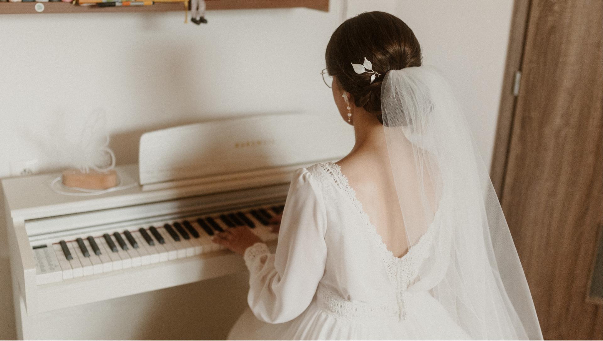Nevesta pri klavíri so svadobnou ozdobou do vlasov a jemným závojom.